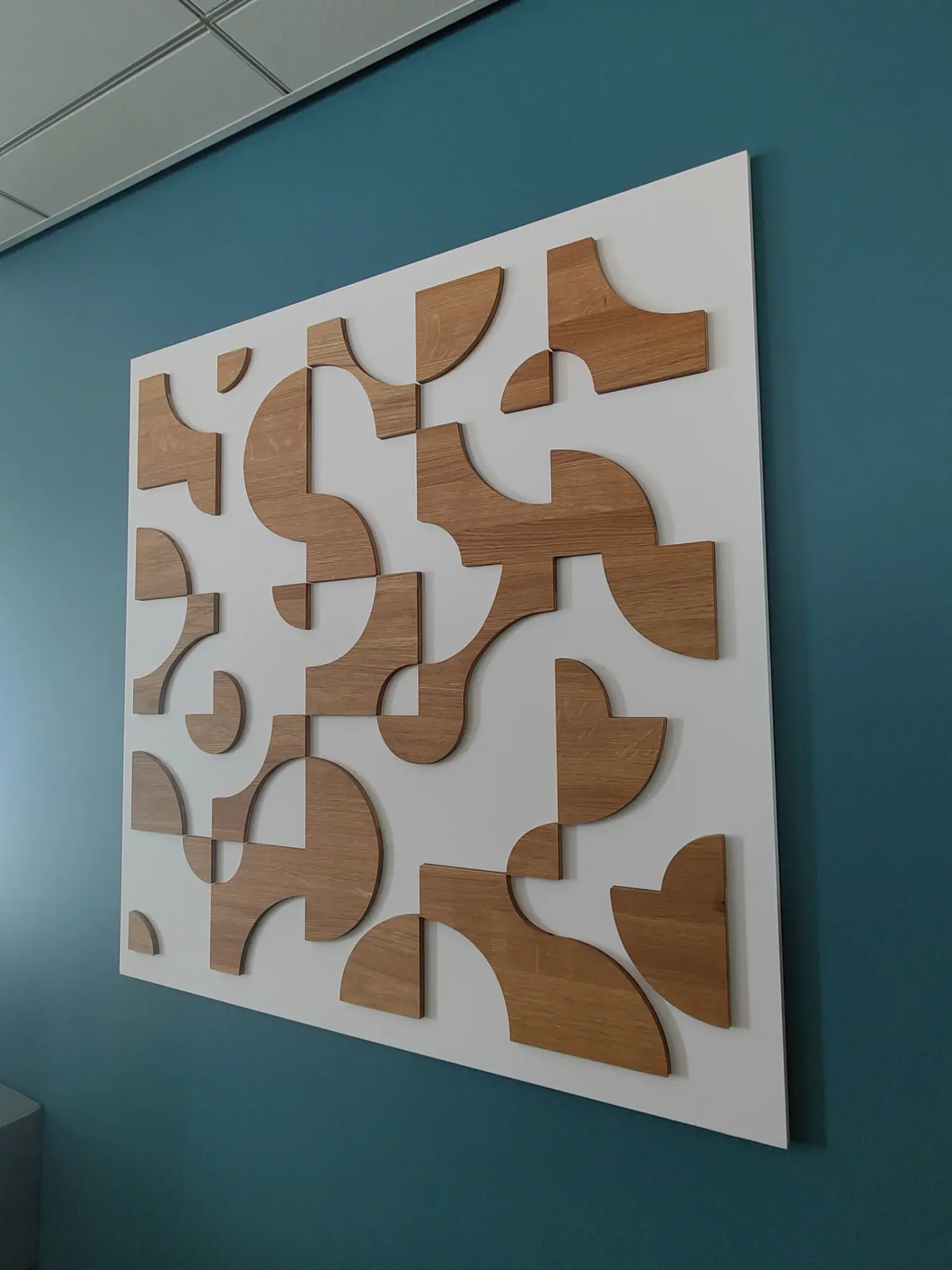Panneau décoratif en relief à formes arrondies bois sur mur bleu canard