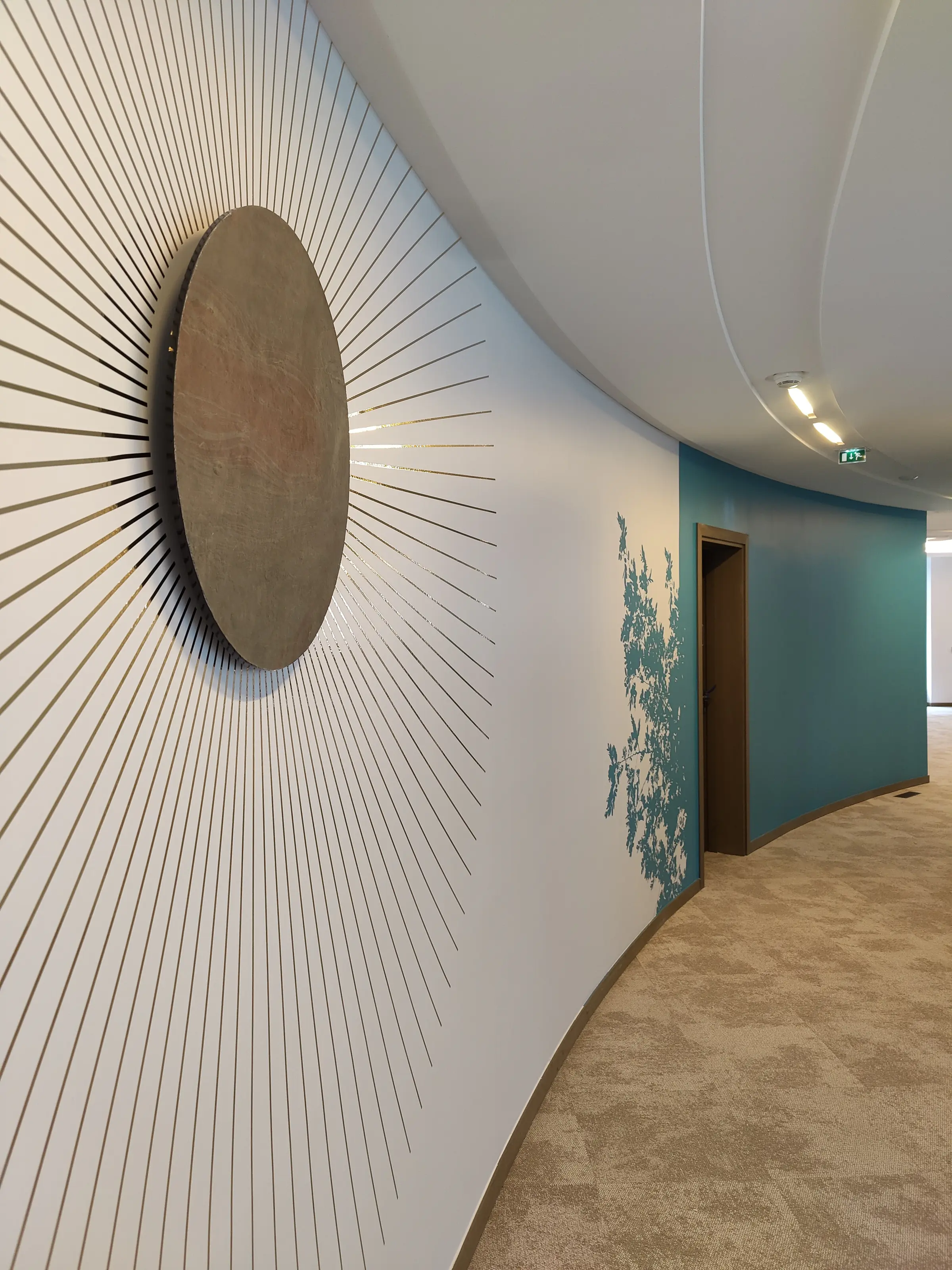 Soleil en bois et rayons adhésifs sur mur courbe, bureaux AXA Opéra