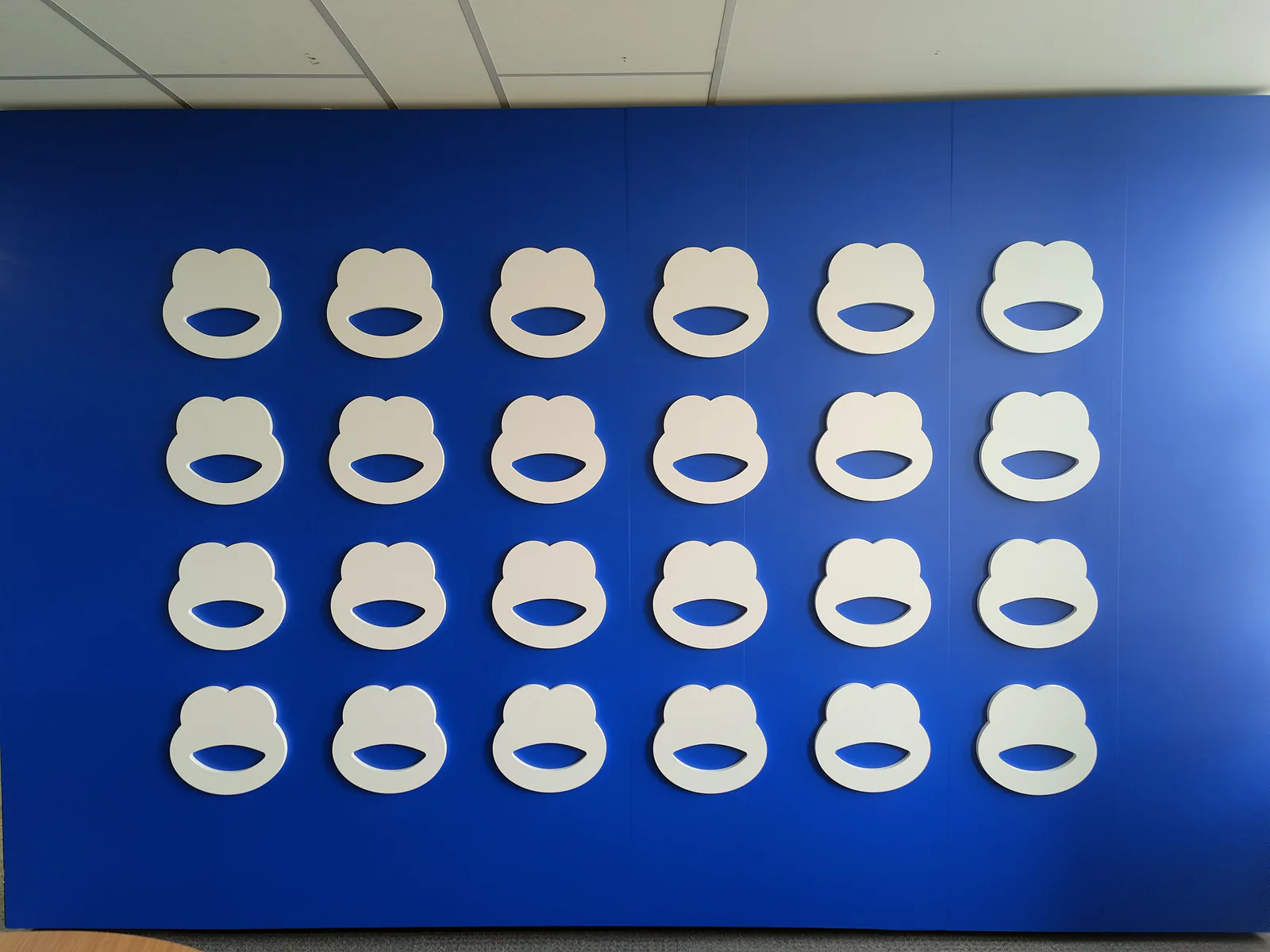 Mur bleu BforBank orné du symbole de la marque répété en relief blanc
