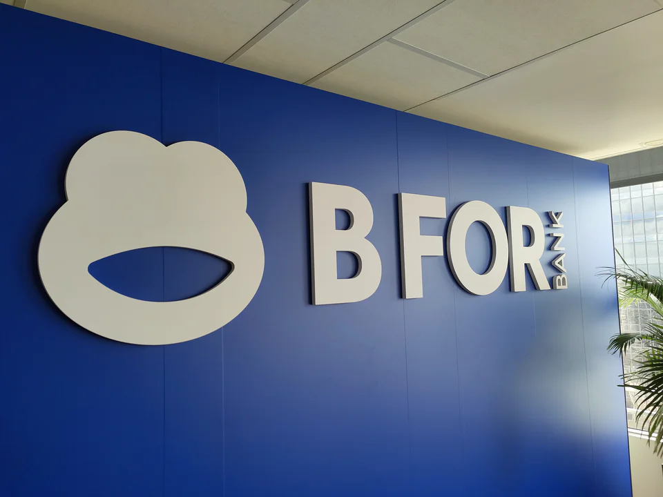 Logo BforBank en relief blanc sur un mur bleu roi