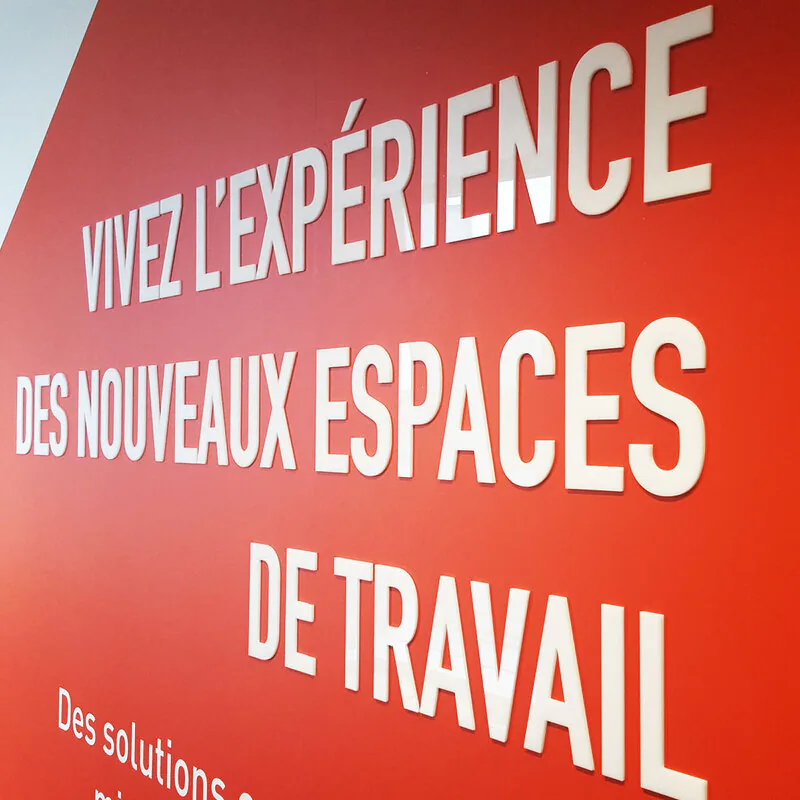 Gros plan sur le lettrage en relief blanc posé sur adhésif rouge, décoration des bureaux de BNP Real Estate