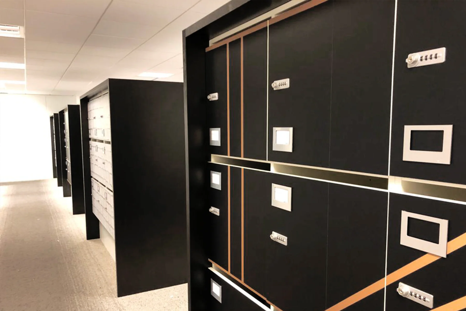 Casiers noirs à filets dorés effet miroir alignés dans un open space, décoration art déco de bureaux par Paristic