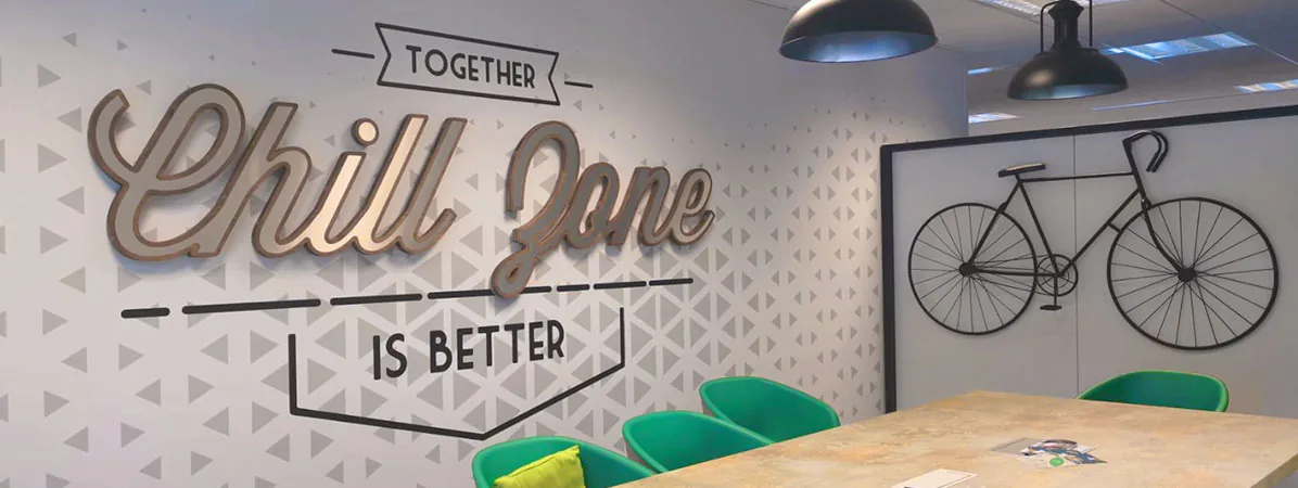 Espace détente : lettrage Together Chill Zone is better en relief et vélo en adhésif noir au-dessus d'une table