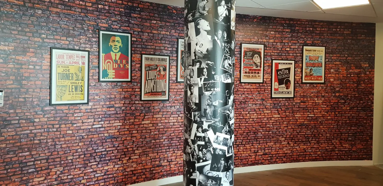 Mur de briques en papier peint et affiches de concerts encadrées