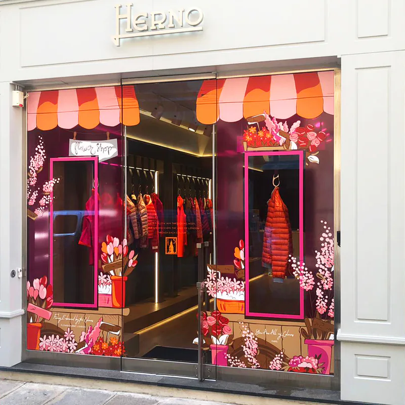 Façade de la boutique Herno à Paris : vitrophanie florale et stores rayés dessinés sur toute la vitrine