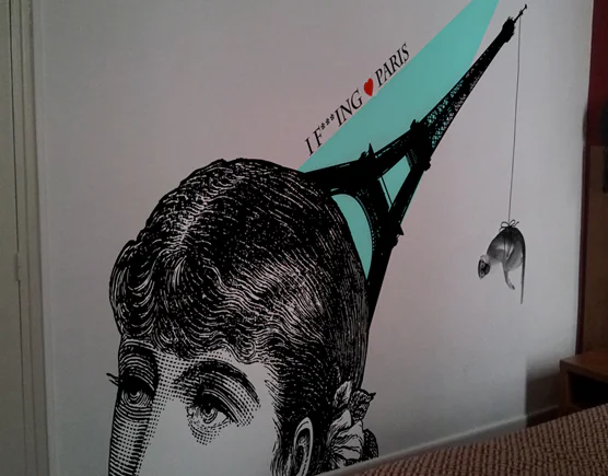 Chambre de l'Hôtel Nation : gravure d'un visage de femme et tour Eiffel turquoise en adhésif mural décalé