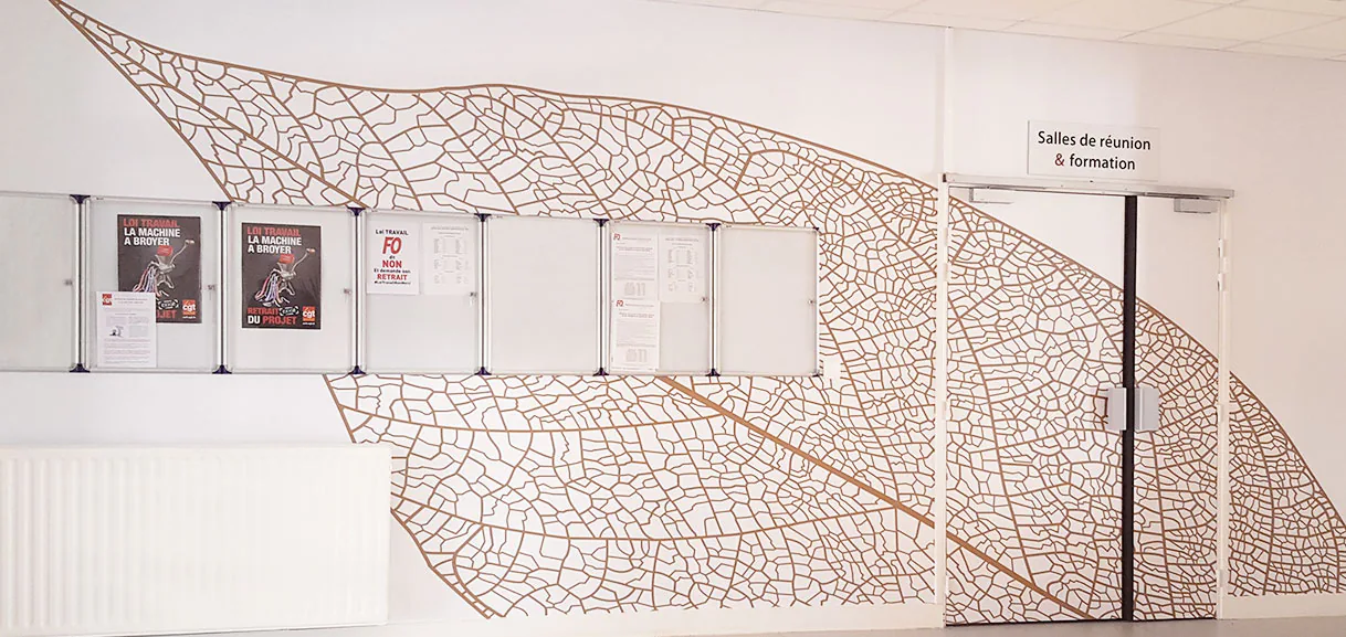 Mur et porte du hall Humanis couverts d'une feuille géante en adhésif, jusqu'à l'accès des salles de réunion