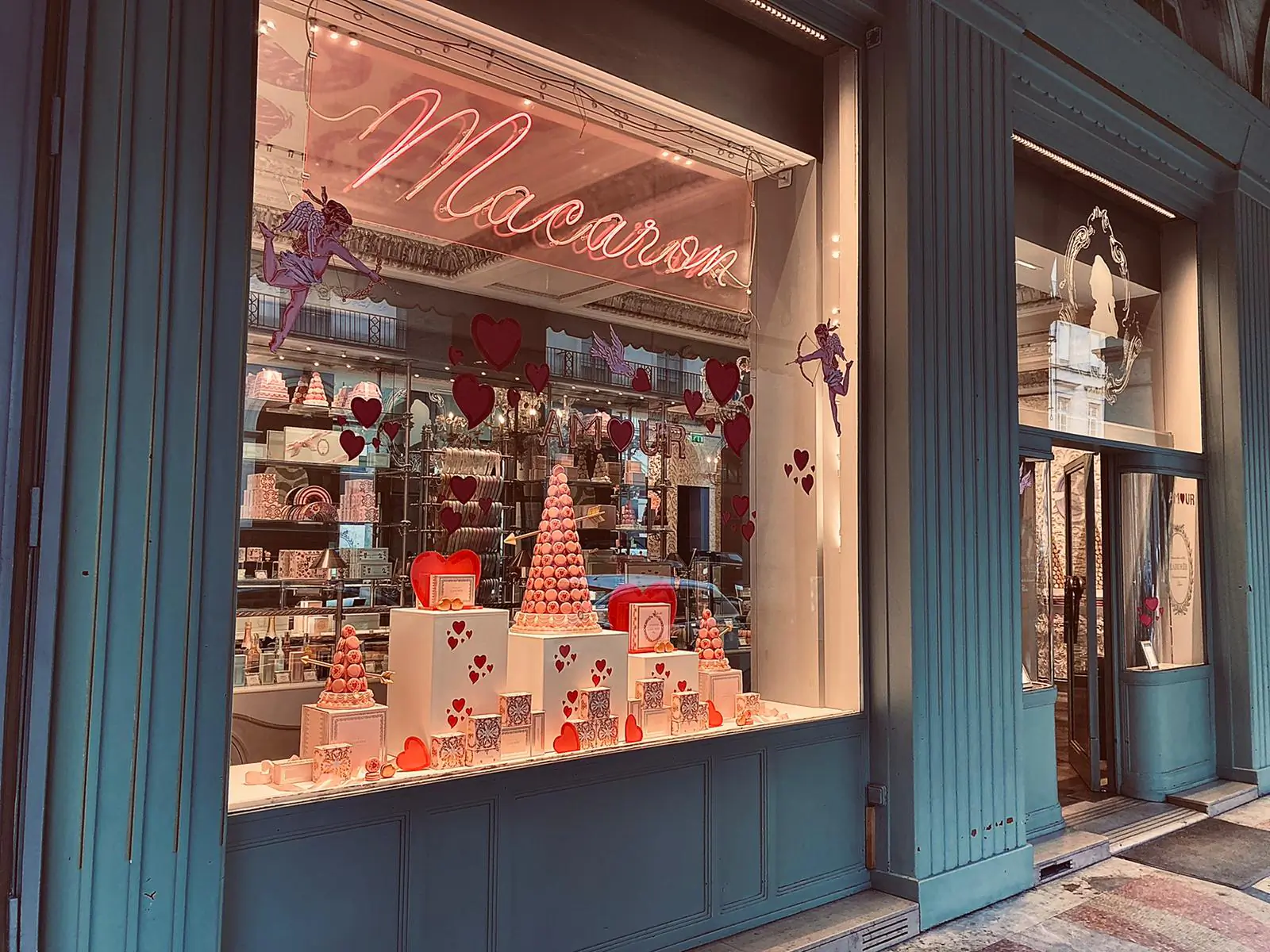 Vitrine Ladurée mise en scène autour de l'enseigne lumineuse « Macaron »
