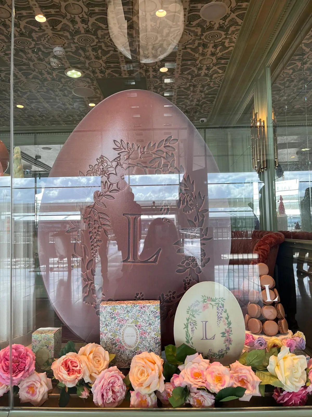 Vitrine de Pâques Ladurée : œuf géant, pyramides de macarons et fleurs
