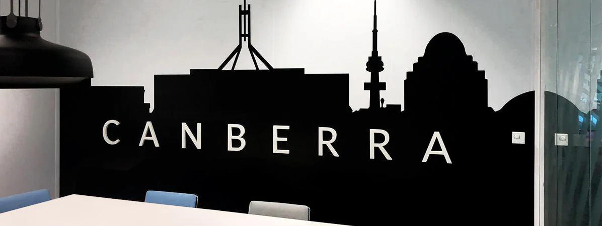 Salle de réunion Canberra chez SNCF : skyline de la ville en adhésif noir et nom de la salle en lettrage blanc