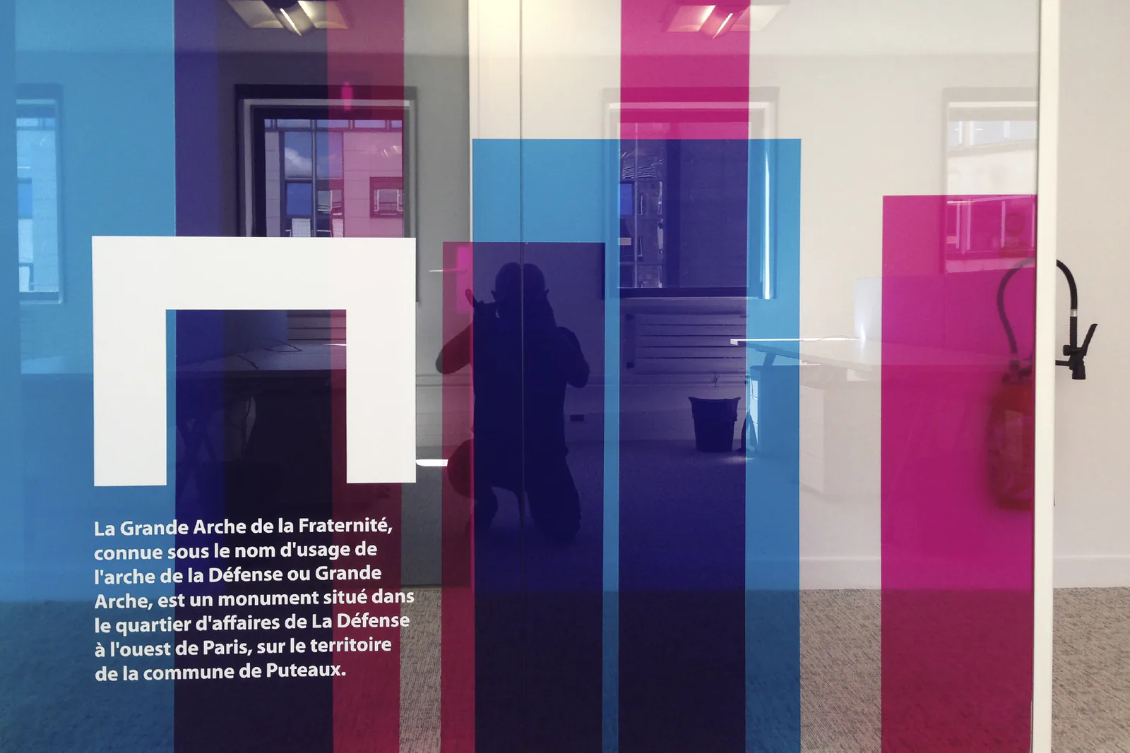 Vitrophanie colorée évoquant la Grande Arche, avec texte descriptif
