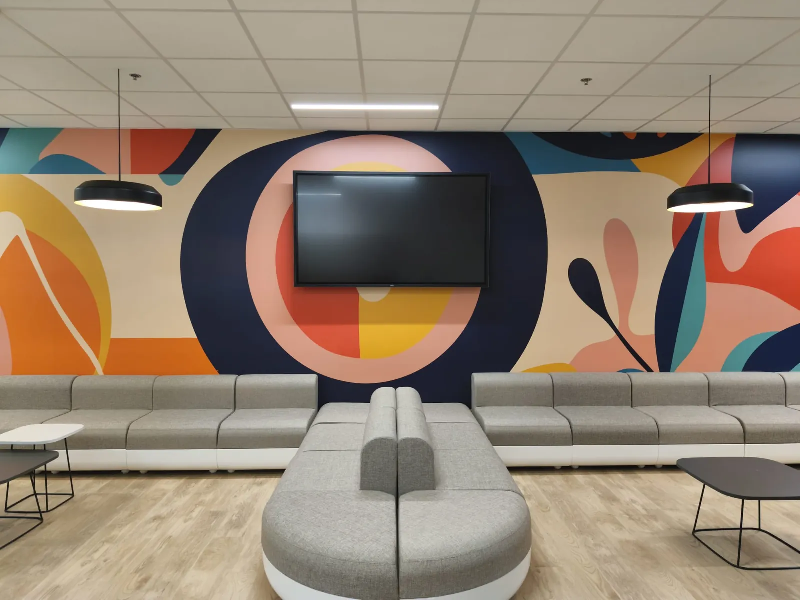Fresque murale graphique aux formes colorées peinte dans l'espace détente de bureaux d'entreprise