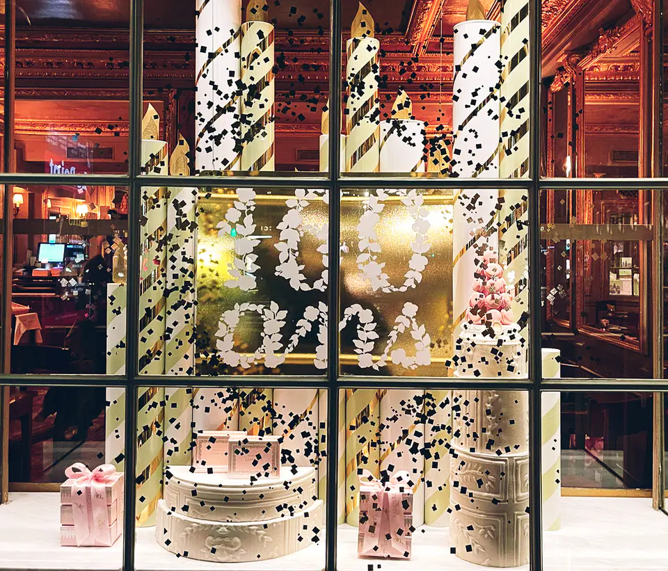 Vitrine de confiserie décorée de rayures dorées, bougies et confettis noirs pour les fêtes