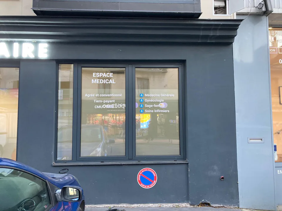 Vitrine d'un espace médical avec le nom et les spécialités inscrits en lettrage blanc