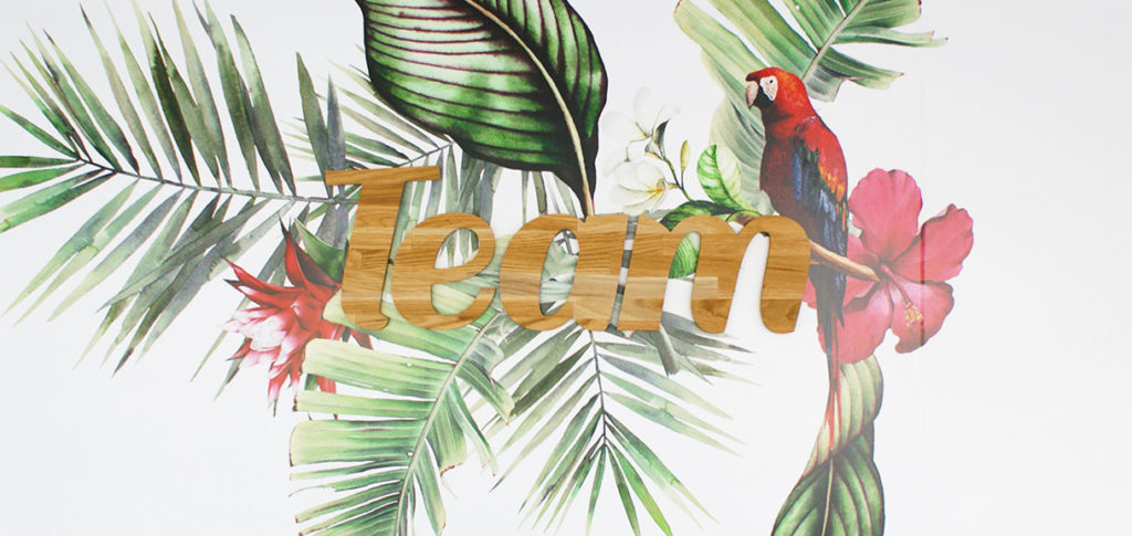 Décoration murale avec logo 3D en bois et stickers au thème tropical
